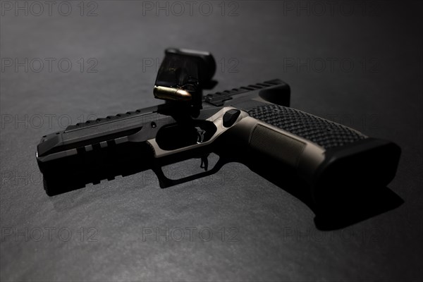 Modern Elegant Handgun and Charger with Bullet on Grey Background in Switzerland
