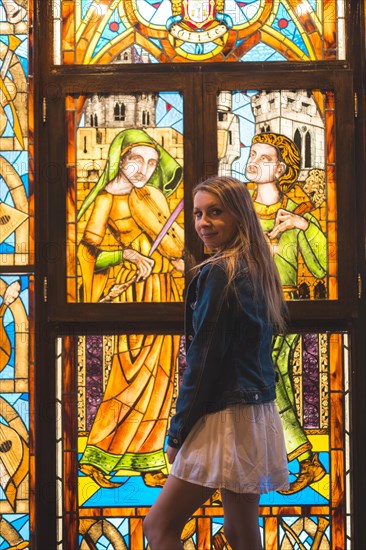 Young blonde caucasian woman in a white dress and denim jacket enjoying a beautiful medieval hotel in the town of Olite in Navarra. Spain