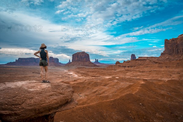 A young woman in a black T-shirt at John Ford's Point looking at the Monument Valley. Utah