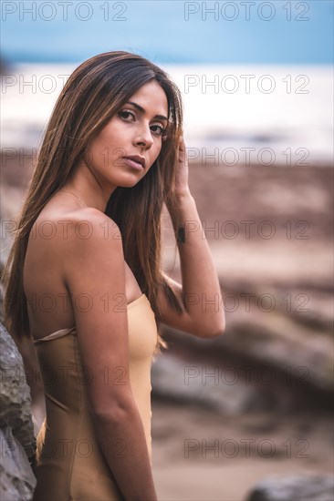 Portrait of a brunette woman in a swimsuit on a beach in summer