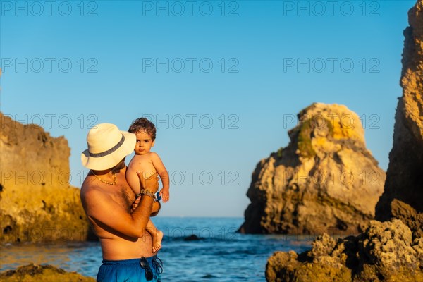 A father with his baby on vacation at Praia dos Arrifes