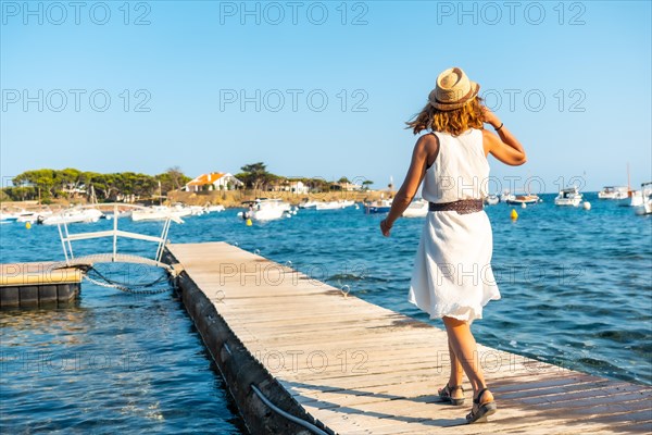 A young woman in a dress in Cadaques walking along the sea