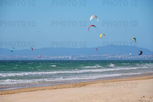 Kiteboarding kitesurfing kiteboarder kitesurfer kites on the Atlantic ocean beach at Fonte da Telha beach