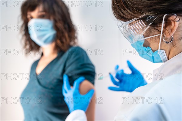 Coronavirus vaccine applied to a young woman by a doctor. Antibodies