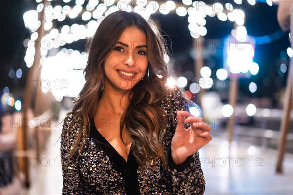 Winter lifestyle at Christmas. Brunette Caucasian girl in a fashionable dress with sequins