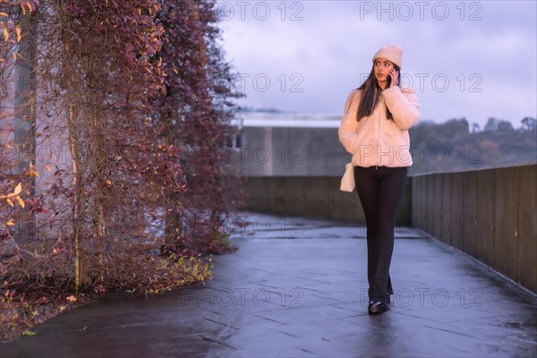 Young pretty Caucasian brunette walking in the city in winter