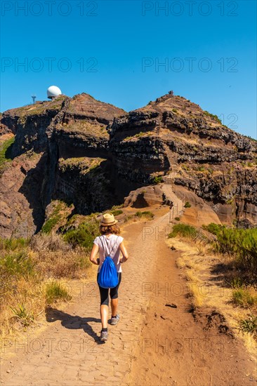 A young woman walking towards Pico do Arieiro from Ninho da