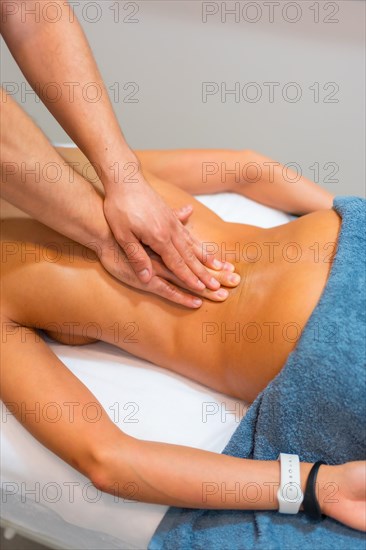 Physiotherapeutic massage to an unrecognizable woman lying on a stretcher on her back