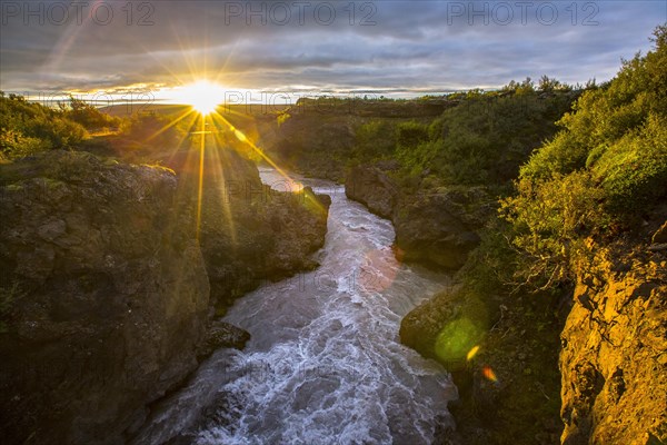 Sunset seen from the wooden bridge of the Barnafoss river