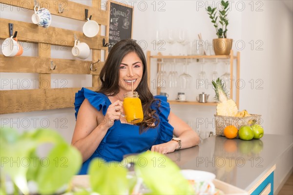 Owner of a cafeteria drinking organic orange juice in the counter