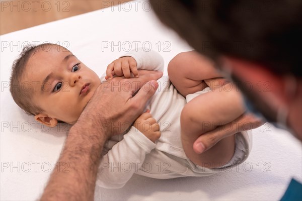 High angle view and close-up of a cute baby during an examination with the doctor