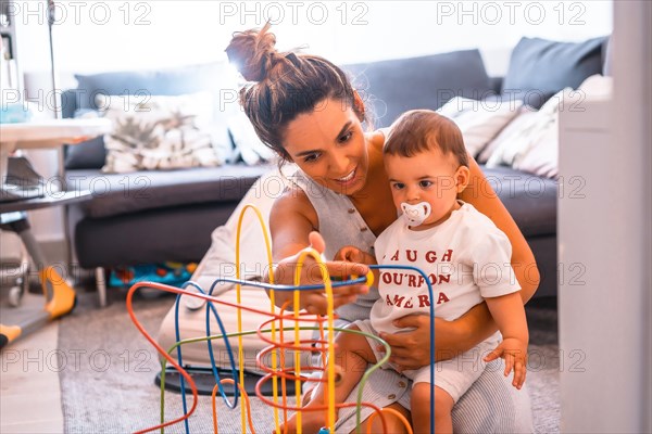 Young Caucasian mother with her son sitting on the floor of their home. Teleworking and caring for your child