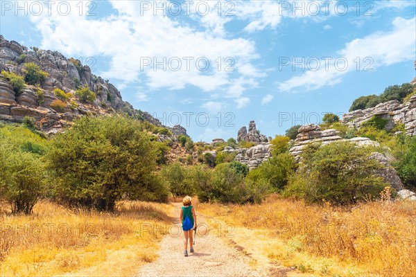 A young woman trekking in the Torcal de Antequera on the green and yellow trail