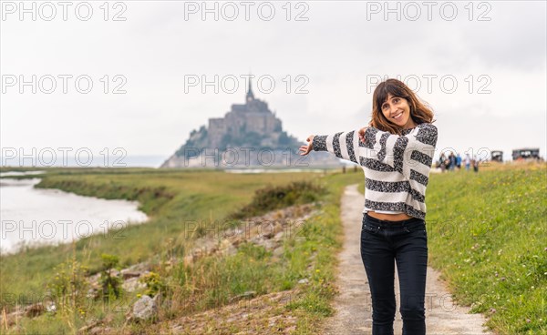 A young tourist walking from Point de Vue towards the Abbey of Mont Saint-Michel