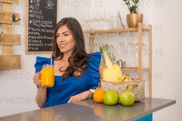 Beauty female owner of a healthy cafeteria drinking orange juice