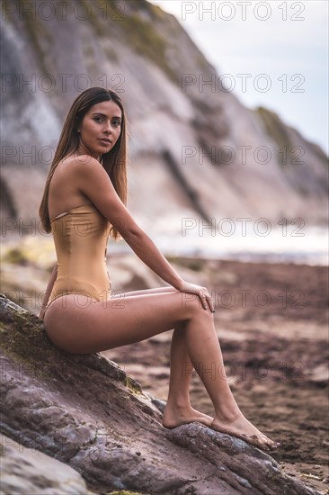 Portrait of a brunette woman in a swimsuit on a beach in summer