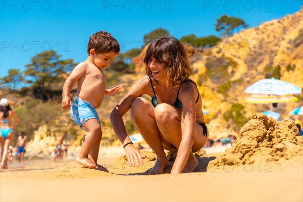 Mother and son playing on the beach at Praia do Barranco das Belharucas