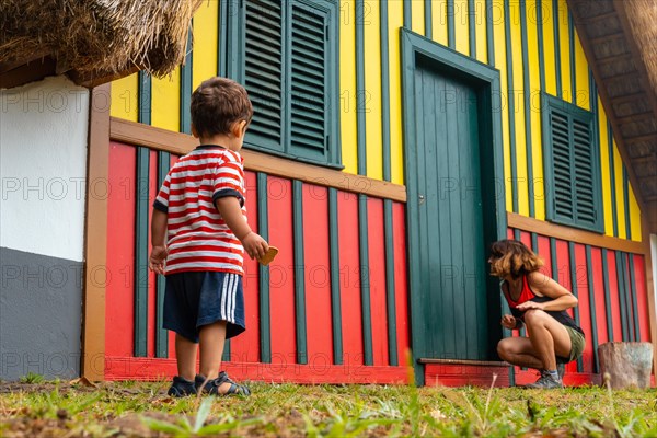 Mother and son playing in a traditional Madeiran house like the ones in Santana in the forest of Caldeirao Verde