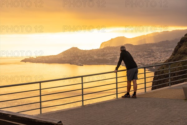 A man at the Mirador de Cristo Rei at sunset in Funchal in summer