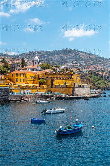 Small fishing boats next to the Forte de Sao Tiago on the beach of Funchal