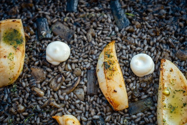 Detail of the black rice with cuttlefish and young garlic with aioli