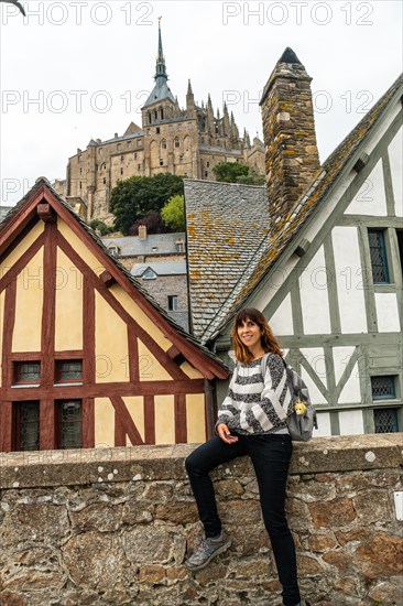 A young woman in the old wooden dwellings at the famous Mont Saint-Michel Abbey in the Manche department