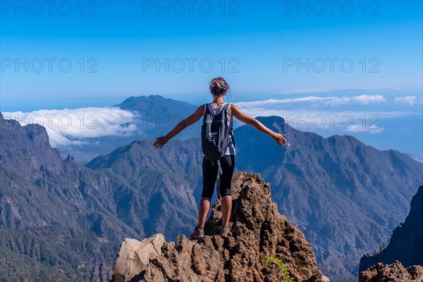 A young woman looking out from the top of the Caldera de Taburiente volcano near Roque de los Muchachos one summer afternoon