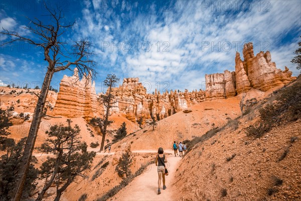 A young woman walking along the giant eroded stones on the Queens Garden Trail