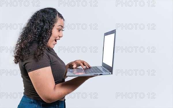 Surprised girl looking at an promotion on laptop screen isolated. Amazed latin woman using laptop isolated. Latin people looking offer promo on laptop isolated