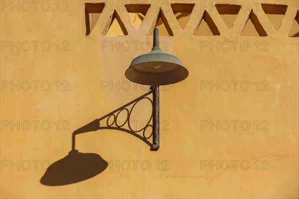 Lantern with shadow on a house wall