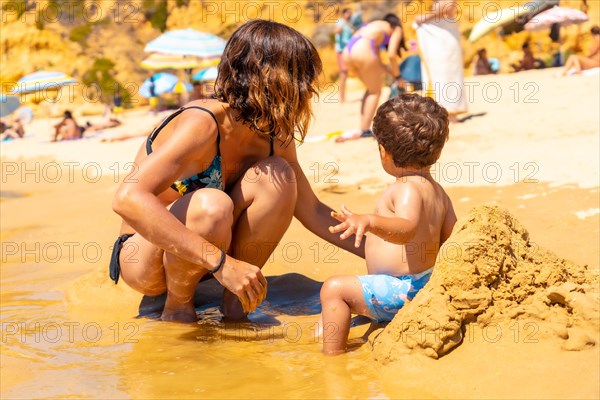 Playing in the sand on the beach at Praia do Barranco das Belharucas