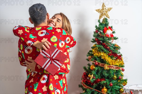 Young couple sitting next to the Christmas tree