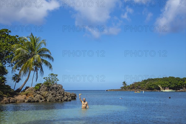 A young man entering the Caribbean Sea at West End Beach on Roatan Island. Honduras