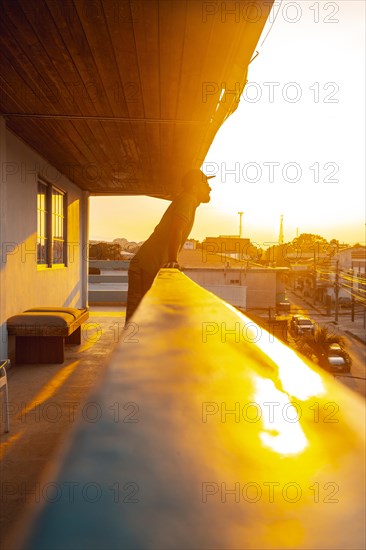 A young tourist looking through a terrace on the coast of Tela in a sunset. Honduras