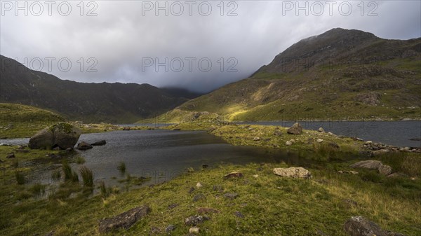 Lake Llyn Llydaw with Mount Snowdon behind clouds in late summer