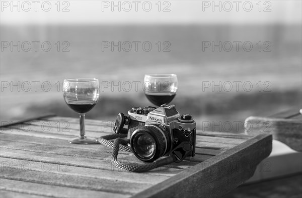 Analogue Nikon camera FE2 and red wine glasses on terrace