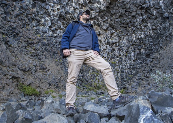 A boy in a fantastic stone shapes on the Jokulsargljufur trekking trail