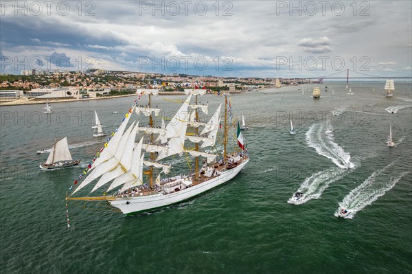 Aerial drone view of tall ships with sails sailing in Tagus river towards the Atlantic ocean in Lisbon