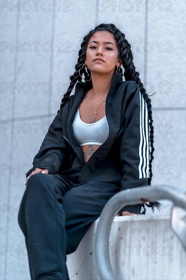 Urban session. Young woman of black ethnicity with long braids and with tattoos