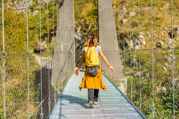 A hiker crossing the Holtzarte suspension bridge