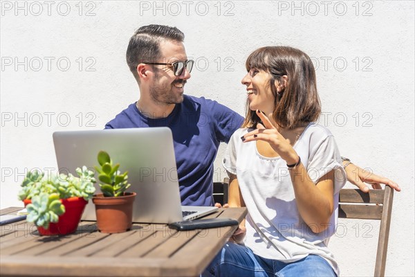 A couple confined at home making a video call with some friends with the computer