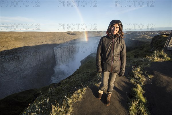 A young woman looking at the Dettifoss Waterfall