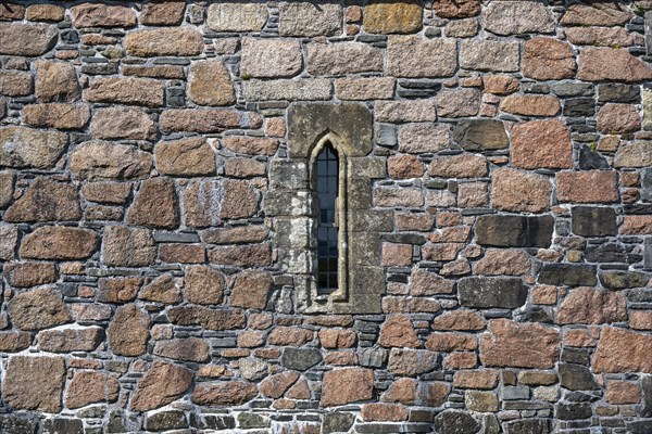 Ross of Mull granite and basalt house wall with a narrow window