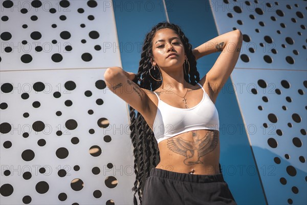 Young woman of black ethnicity with long braids and tattoos