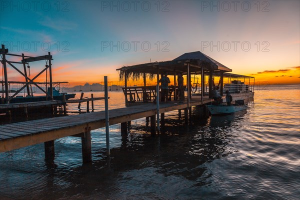 A pier and the boat in the background on a beach on Roatan Island. Honduras