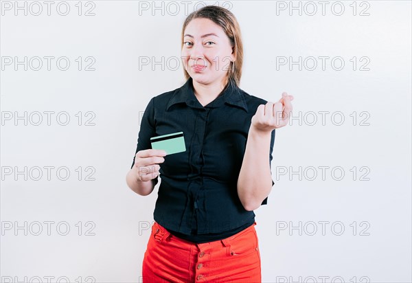 Attractive young woman holding credit card making money gesture with fingers isolated