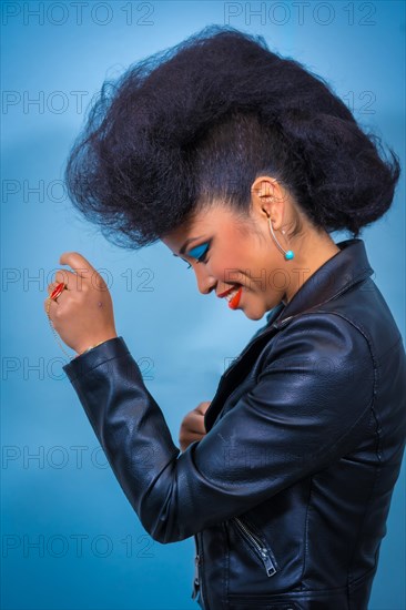 A closeup portrait of a fashion attractive rocker style woman with bright makeup wearing a leather jacket