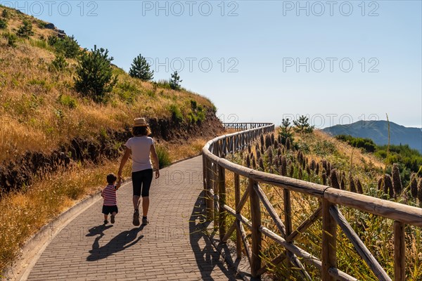 A mother walking with her son at the viewpoint of Miradouro do paredao