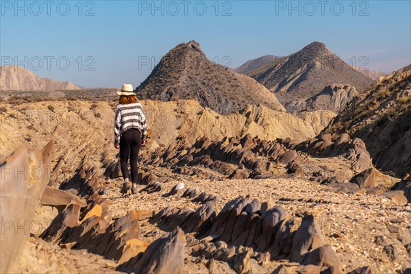 A young hiker girl visiting the landscapes of Colas de Dragon in the desert of Tabernas