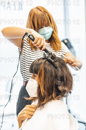 Hairdresser with mask and client